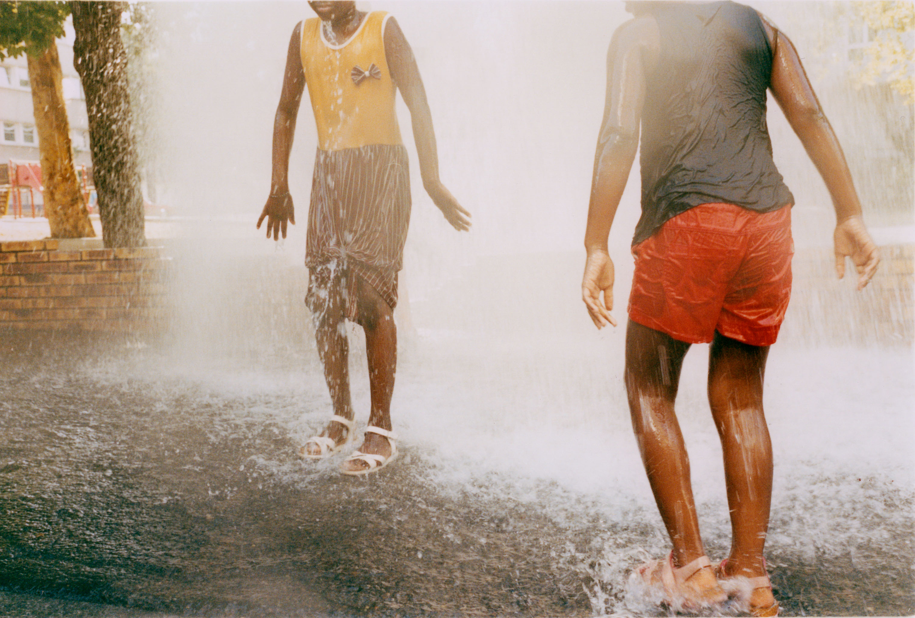 Kids keeping cool in my street during the heatwave. From my ongoing project *Paris Nord*, documenting my local neighbourhood in the suburb of Seine Saint Denis, which can be viewed in its entirety in the *Studies* section of this website. - © Maciek Pożoga